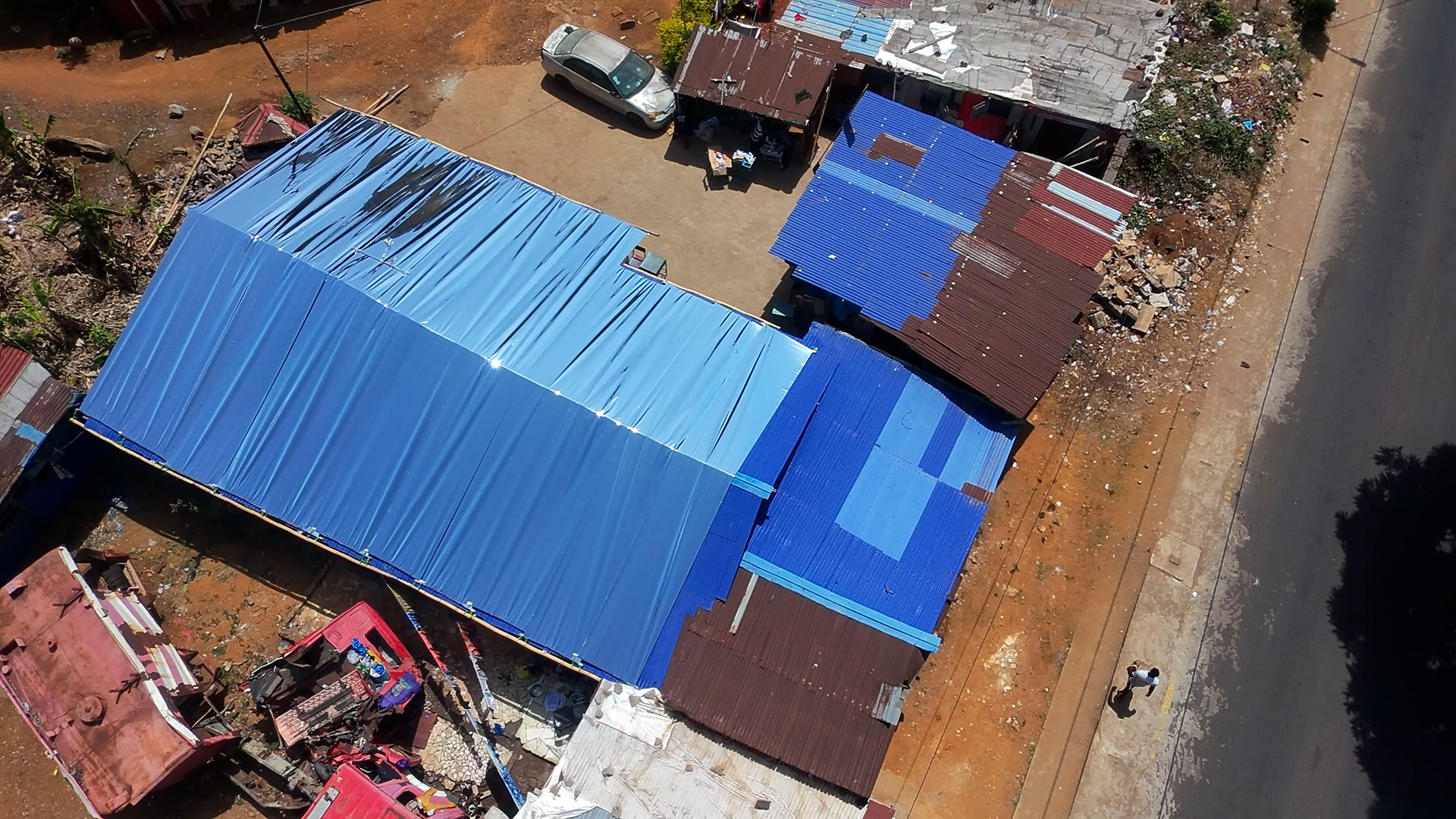 Aerial view of reflective blue roofs across a neighbourhood