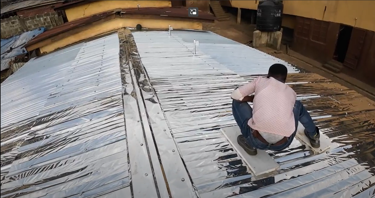Securing the reflective roof surface during installation at the FAWE site.