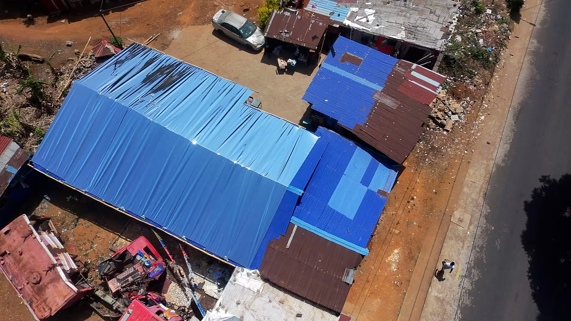 Aerial view of reflective blue roofs across a neighborhood